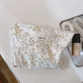 Detailaufnahme der Kosmetiktasche mit Hasenmuster und 'simple wish' Stoffetikett - Hase mit gelben Blumen