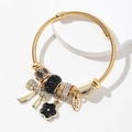 Bracelet jonc doré en spirale avec breloques cœur, nœud et fleurs en cristaux - Noir