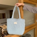 Detailansicht hellblaue Tasche mit Blasenstruktur und weißem gewebtem Etikett - Blasen-Blau