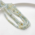 Perline cilindriche in pietra naturale 4x2mm blu chiaro e gialle in un vassoio bianco - Amazonite