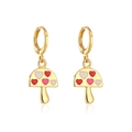 Detalle macro de pendientes de champiñón dorados con patrones de corazón rojo - Champiñón de corazón rojo blanco y rosa