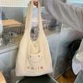 Dettaglio della borsa tote in peluche bianca con ricamo smile e tracolla confortevole - Stile Sorriso