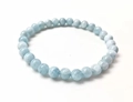 Close-up of light blue natural stone beaded bracelet with smooth round beads and texture - Aquamarine Blue