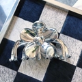 Metallic silver flower-shaped hair claw clip with mirror finish on checkered background - Flower Shape (3)