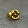 Macro detail of vintage gold compass signet ring with engraved side star patterns - Gold