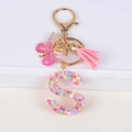 Pink resin letter S keychain with glitter butterfly, tassel and floral sequins - Letter S