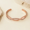 Detailopname van roségouden gevlochten armband met glinsterende kristallen - 14k / Roségoud