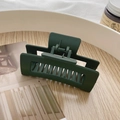 Matte dark green large hair claw clip for women on a rustic wooden tray - Matte Dark Green Hollow Hair Claw