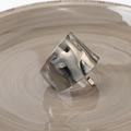 Macro detail of silver textured metal ring with irregular lava wave pattern on a ceramic base - Narrow Edge Silver