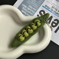 Handmade green wool felt pea pod keychain with smiley faces on a ceramic tray - Pea Pod