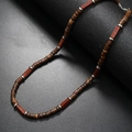 Ethnic style necklace with brown coconut shell beads and silver accents on a black base - Red Brick Stone