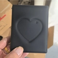 Detail of hand holding a black heart cutout photocard holder made of soft material - Jelly Black