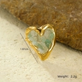 Detail of heart ring with 18K gold frame and green natural stone inlay on rocky ground - One Size / Green