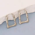 Detail of silver bamboo textured geometric earrings on white stone display base - Silver Style K7-42