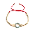 Macro detail of red string bracelet with gold beads and turquoise zircon pendant - Light Blue Zircon Gold Beads Red Rope