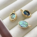 Macro detail of three oval 14k gold-filled abalone shell pendants on velvet tray - 18K Gold Plated Border Abalone Shell