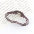 Irregular grayish purple hair claw clip in matte finish displayed on an open book - Grey Purple