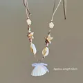 Detalle del colgante de estrella de mar y concha en cordón marrón, largo aprox. 63cm - Blanco-Café (Collar de Concha con Perla y Lazo)
