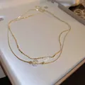 Collana a doppio strato dorata con perla aurora mermaid e sfere metalliche lucide - Girocollo Multistrato con Perla Iridescente