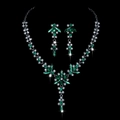 Dettaglio del set di gioielli con gemme verdi e cristalli brillanti su sfondo nero profondo - Strass Verde Placcato Nero