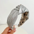 Close-up of silver knot headband featuring metallic faux leather and polka dot lining - Contrast Knotted / Silver