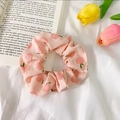 Pink scrunchie with peach pattern made of organza fabric on a book and tulips - Pink Heart Apple