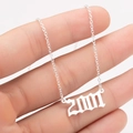 Macro view of silver 2001 year charm on a stainless steel gothic birthday gift necklace - 2001 / Steel