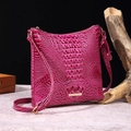 Magenta crossbody bag with crocodile texture and gold hardware on marble surface - Dragon Fruit