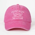 Close-up of vintage 1973 printed text on rose pink washed cotton baseball cap texture - One Size / Rose Red