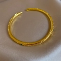 Vintage gold open bangle with embossed texture and green gemstones on champagne silk - Bracelet-Gold