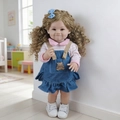 Detail of 55cm reborn baby doll with long blonde curls and denim dress in cozy setting - Denim Dress Curly Hair Smiling Face / Doll Clothes (Outfit Only)