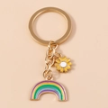 Portachiavi cuore dorato con arcobaleno e ciondolo margherita su sfondo rosa - Margherita Gialla