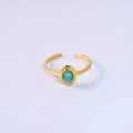 Detail of gold open ring with oval light blue gemstone on white fabric background - Amazonite