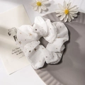 White organza scrunchie with gold star sequins displayed on a ceramic plate - Star White