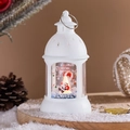 Detail der weißen Weihnachtslaterne mit Weihnachtsmann-Motiv und warmem Licht - Weihnachtsmann