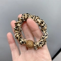 Detail of leopard print scrunchie with sparkling gold rhinestone ball decoration - Satin Leopard