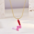 Detailed close-up of the colorful enamel dripping pendant on the gold choker necklace - Letter W