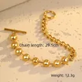 Dettaglio di un bracciale dorato in acciaio con perle tonde e chiusura classica a levetta OT - Bracciale Oro / Oro 18K