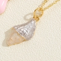 Detailed macro view of the gold seashell pendant with glistening resin and fine textures - Grey Shell