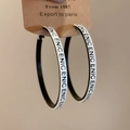 Dettaglio di grandi orecchini a cerchio con lettere ENIC e contrasto bianco e nero - Orecchini a Cerchio con Stampa di Lettere in Bianco e Nero (42#)