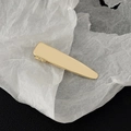 Polished gold metal hair clip detail on artistic white paper and black leather background - Gold Minimalist Smooth Style