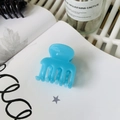 Glossy blue medium-sized plastic claw clip for ponytail on a styled aesthetic background - French Blue (Medium 4.8cm)