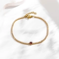 Detailaufnahme des Goldarmbands mit weißen Zirkonia und einem zentralen roten Edelstein - Runder Roter Zirkonia