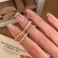 Set of four minimalist silver and gold rings with fine diamonds on a female model hand - Gold Beaded Thin (JZ1081)