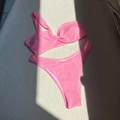 Flat lay of pink one-shoulder bikini set featuring embossed texture and knot detail - S / Pink