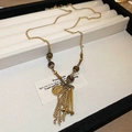 Detail of vintage gold coin pendant with tassels and brown beads on jewelry tray - 2# Necklace - Gold Tassel