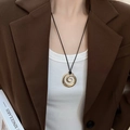 Irregular golden spiral C-shaped pendant necklace with black cord on model - Gold Spiral with Black Cord