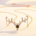 Detailed macro of rose gold antler necklace featuring center projection stone and crystals - Buck Antler Rose Gold