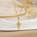 Detailed view of a gold arrow pendant necklace with cubic zirconia and Greek key pattern - Gold Geometric Arrow Key Zirconia Style (XL0470)