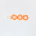 Close-up of three orange embroidered yarn flowers on a ribbon-wrapped hair clip - Orange